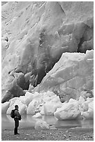 Hiker looking at ice wall at the terminus of Reid Glacier. Glacier Bay National Park, Alaska, USA. (black and white)
