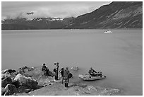 Film crew met by a skiff after shore excursion. Glacier Bay National Park, Alaska, USA. (black and white)