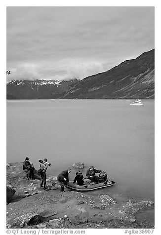 Film crew embarking on a skiff after shore excursion. Glacier Bay National Park (black and white)