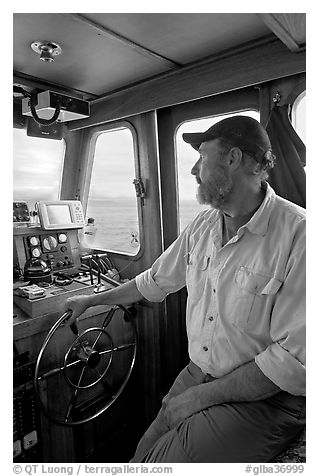 Captain steering boat using navigation instruments. Glacier Bay National Park (black and white)