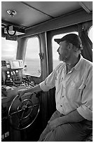 Captain steering boat using navigation instruments. Glacier Bay National Park, Alaska, USA. (black and white)