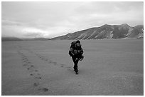 Backpacker hikes in sand-like ash, Valley of Ten Thousand smokes. Katmai National Park, Alaska (black and white)