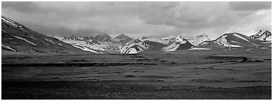 Desert-like ash-covered valley surrounded by snowy peaks. Katmai National Park (Panoramic black and white)
