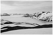 Dark bands of freshly uncovered terrain, snow, and low clouds, dusk. Kenai Fjords National Park, Alaska, USA. (black and white)