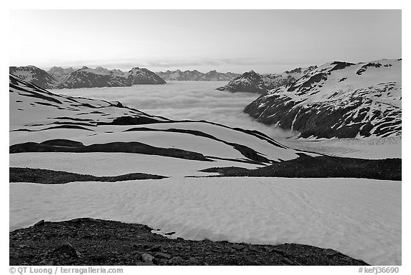 Bands freshly uncovered by snow, and low clouds, sunrise. Kenai Fjords National Park, Alaska, USA.