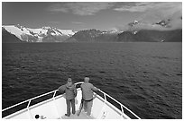 Passengers with red jackets on bow of tour boat, Northwestern Fjord. Kenai Fjords National Park, Alaska, USA. (black and white)