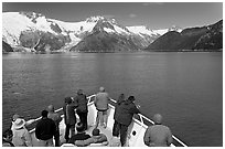 Vistors on bow of tour boat approaching glacier, Northwestern Fjord. Kenai Fjords National Park, Alaska, USA. (black and white)