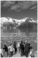 People looking as tour boat slows down for iceberg, Northwestern Fjord. Kenai Fjords National Park, Alaska, USA. (black and white)