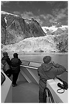 Passengers looking at Northwestern glacier from the deck of tour boat. Kenai Fjords National Park, Alaska, USA. (black and white)