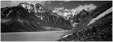 Rugged mountains rising above lake with turquoise waters. Lake Clark National Park (Panoramic black and white)