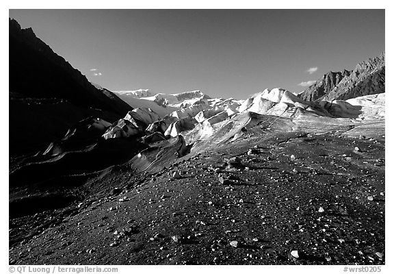 Morainic debris on Root glacier with Wrangell mountains in the background, late afternoon. Wrangell-St Elias National Park, Alaska, USA.