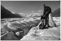 Hiker reaching into backpack on Root glacier. Wrangell-St Elias National Park ( black and white)