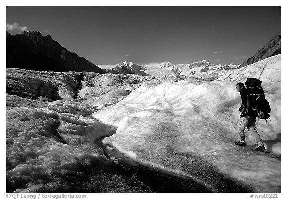 Backpacker with large pack on Root glacier. Wrangell-St Elias National Park (black and white)