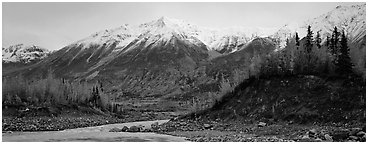 Autumn mountain landscape with snowy peaks above river and trees. Wrangell-St Elias National Park (Panoramic black and white)
