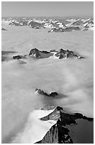 Aerial view of ridges and summits emerging from sea of clouds, St Elias range. Wrangell-St Elias National Park, Alaska, USA. (black and white)