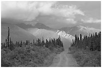 Gravel road leading to mountains lit by sunset light. Wrangell-St Elias National Park ( black and white)