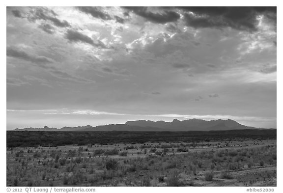 Dry riverbed, distant Chisos Mountains, and clouds. Big Bend National Park, Texas, USA.