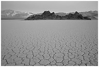 Tiles in cracked mud and Grand Stand, Racetrack playa, dusk. Death Valley National Park, California, USA. (black and white)