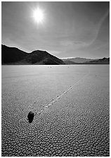 Tracks and moving rock on the Racetrack, mid-day. Death Valley National Park, California, USA. (black and white)