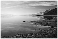 Flooded Badwater basin and Black mountain reflections, early morning. Death Valley National Park, California, USA. (black and white)