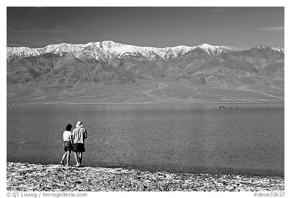 Couple watches the dragon in ephemeral lake. Death Valley National Park, California, USA.