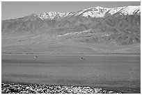 Kayakers in ephemeral Manly lake, and Panamint Range. Death Valley National Park, California, USA. (black and white)