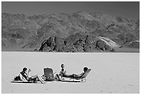 Tourists sunning themselves with beach chairs on the Racetrack. Death Valley National Park ( black and white)