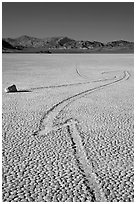 Zig-zagging track and sailing stone, the Racetrack playa. Death Valley National Park, California, USA. (black and white)