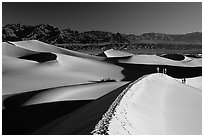 Dune field with hikers, Mesquite Dunes. Death Valley National Park, California, USA. (black and white)