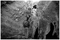 Hikers climbing in a narrow side canyon. Death Valley National Park, California, USA. (black and white)