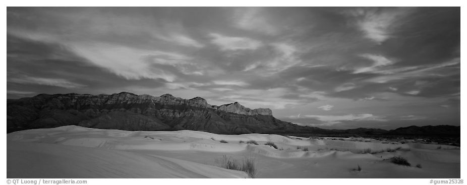 White sand dunes, mountain range, and colorful clouds. Guadalupe Mountains National Park (black and white)