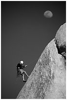 Climber rappelling down with moon. Joshua Tree National Park, California, USA. (black and white)