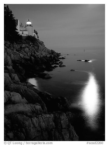 Bass Harbor lighthouse by night with reflections of moon and lighthouse light. Acadia National Park (black and white)