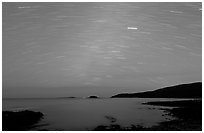 Star trails above coast, Schoodic Peninsula. Acadia National Park, Maine, USA. (black and white)