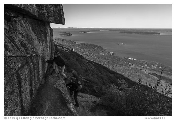 Hikers on ledge with handrails, Precipice Trail. Acadia National Park (black and white)