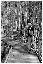 Hiker with backpack standing on boardwalk. Congaree National Park ( black and white)