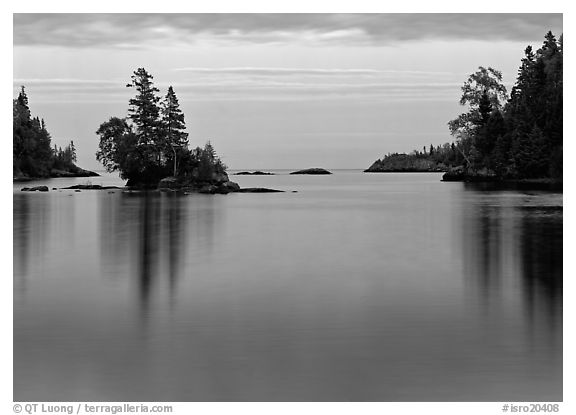 Tree-covered islet and smooth waters, Chippewa Harbor. Isle Royale National Park, Michigan, USA.