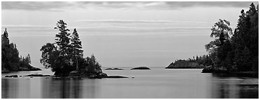 Tree-covered islet at dawn. Isle Royale National Park (Panoramic black and white)