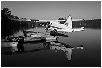 Pilot opening door at floatplane dock. Isle Royale National Park ( black and white)