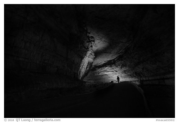 Ranger with lantern backlighted in dark cave corridor. Mammoth Cave National Park (black and white)