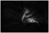 Ranger with lantern backlighted in dark cave corridor. Mammoth Cave National Park ( black and white)