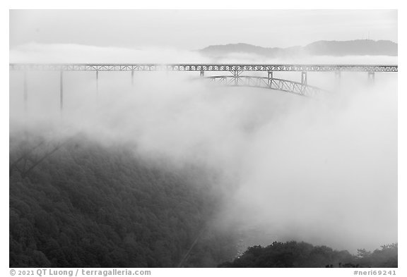 New River Gorge Bridge rising from low fog at dawn. New River Gorge National Park and Preserve (black and white)