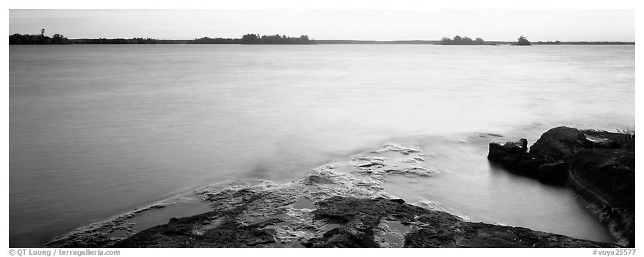 Lakeshore and glassy water painted yellow by sunrise. Voyageurs National Park (black and white)