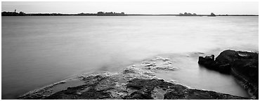 Lakeshore and glassy water painted yellow by sunrise. Voyageurs National Park (Panoramic black and white)
