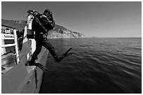 Scuba diver stepping out of boat, Santa Cruz Island. Channel Islands National Park, California, USA. (black and white)