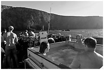 Divers relaxing in hot tub aboard the Spectre and Annacapa Island. Channel Islands National Park, California, USA. (black and white)