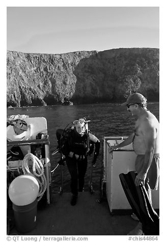 Woman diver stepping onto boat and Annacapa Island. Channel Islands National Park (black and white)