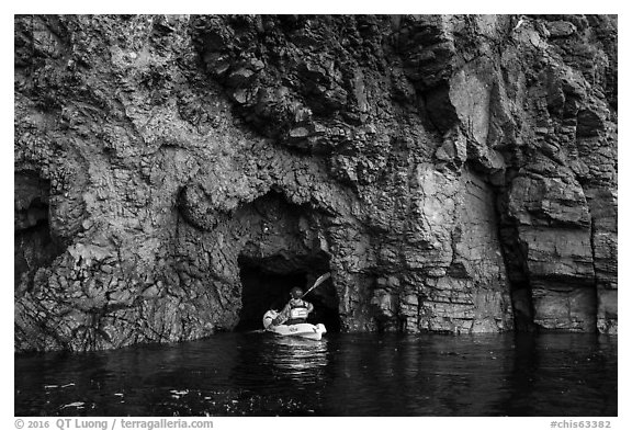 Kayaker entering narrow sea cave, Santa Cruz Island. Channel Islands National Park (black and white)