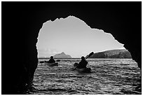 Kayakers exiting sea cave with West Anacapa in the distance, Santa Cruz Island. Channel Islands National Park ( black and white)