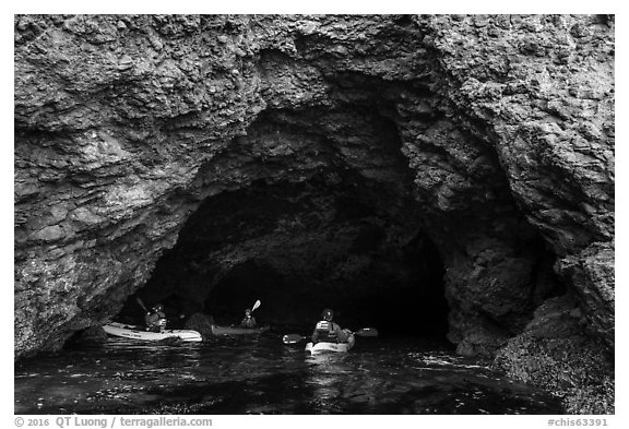 Kayakers at the entrance of sea cave, Santa Cruz Island. Channel Islands National Park (black and white)